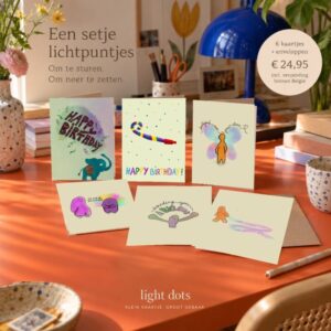 Een setje lichtpuntjes: zes originele Light Dots-wenskaarten op een warm oranje bureau, zonder losse envelopstapel.